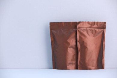 Photo of Two zipper stand-up pouches on light grey background. Mockup for design