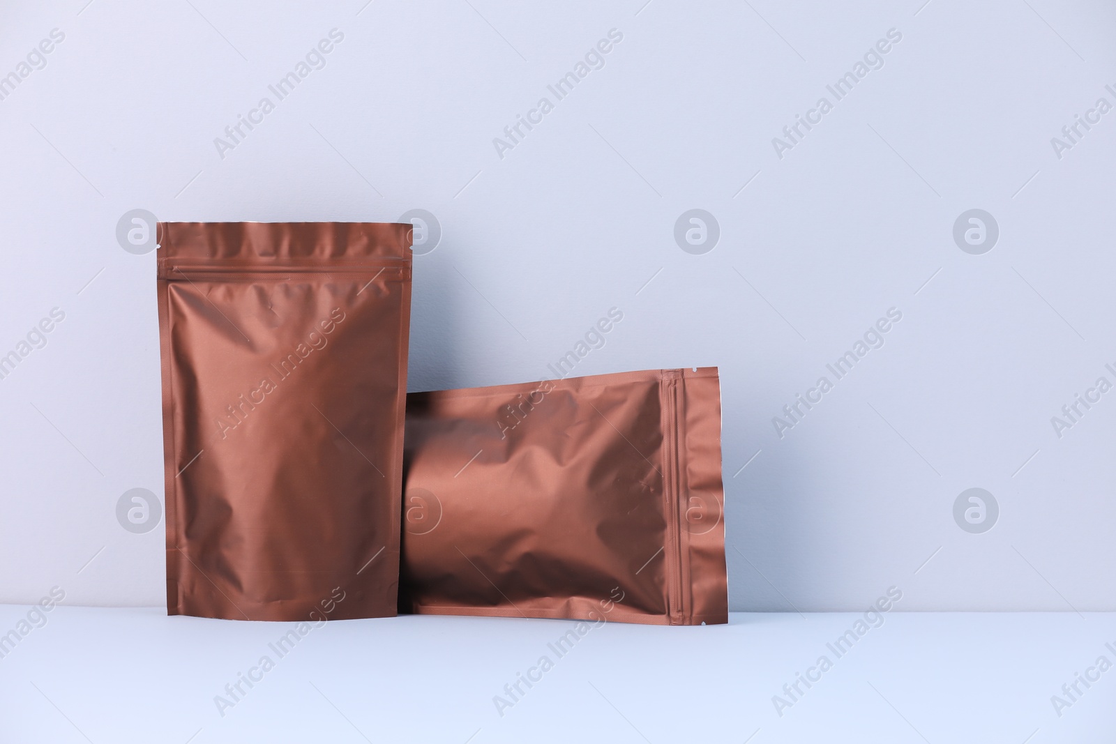 Two zipper stand-up pouches on light grey background. Mockup for design Photo of Two zipper stand-up pouches on light grey background. Mockup for design