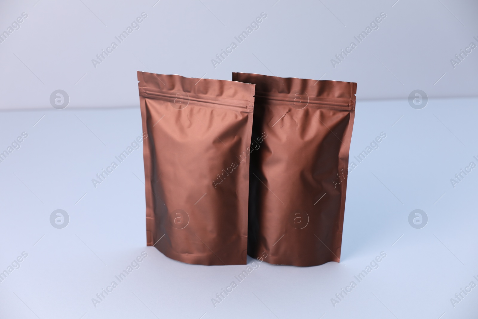 Two zipper stand-up pouches on light grey background. Mockup for design Photo of Two zipper stand-up pouches on light grey background. Mockup for design