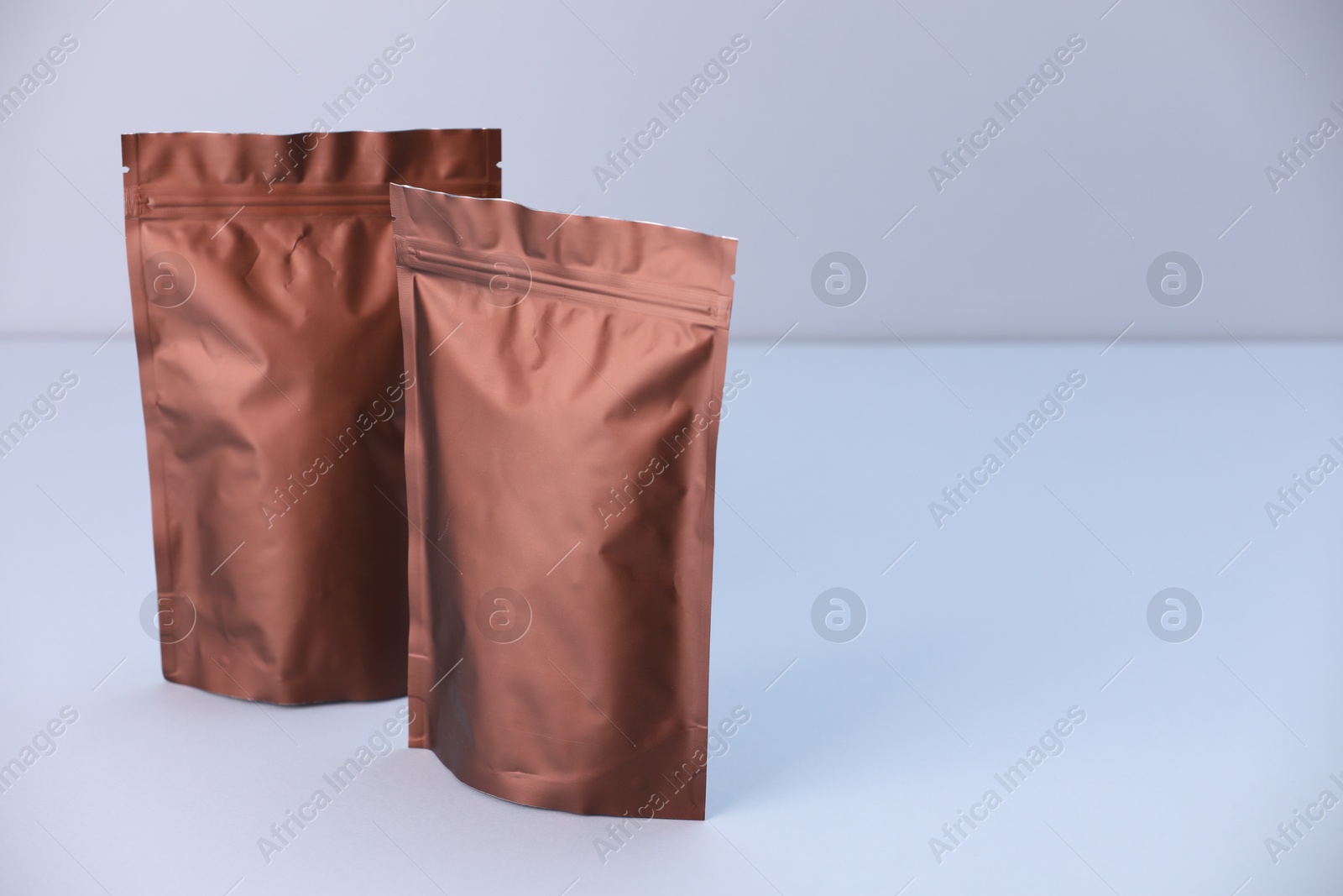 Two zipper stand-up pouches on light grey background. Mockup for design Photo of Two zipper stand-up pouches on light grey background. Mockup for design