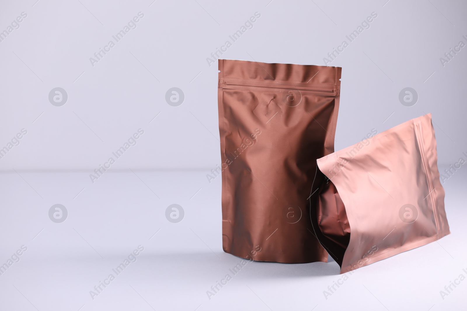 Two zipper stand-up pouches on light grey background. Mockup for design Photo of Two zipper stand-up pouches on light grey background. Mockup for design