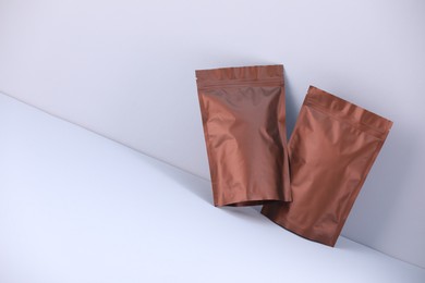 Photo of Two zipper stand-up pouches on light grey background. Mockup for design