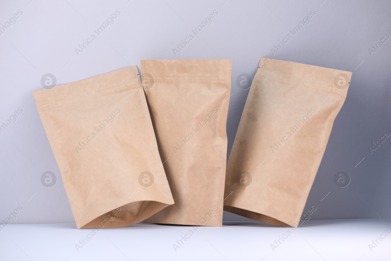 Zipper stand-up pouches on light grey background. Mockup for design Photo of Zipper stand-up pouches on light grey background. Mockup for design