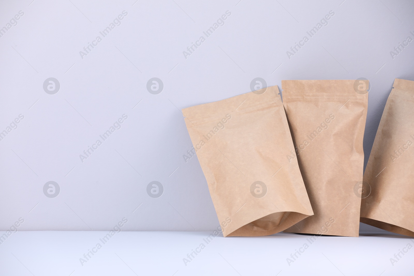 Zipper stand-up pouches on light grey background. Mockup for design Photo of Zipper stand-up pouches on light grey background. Mockup for design