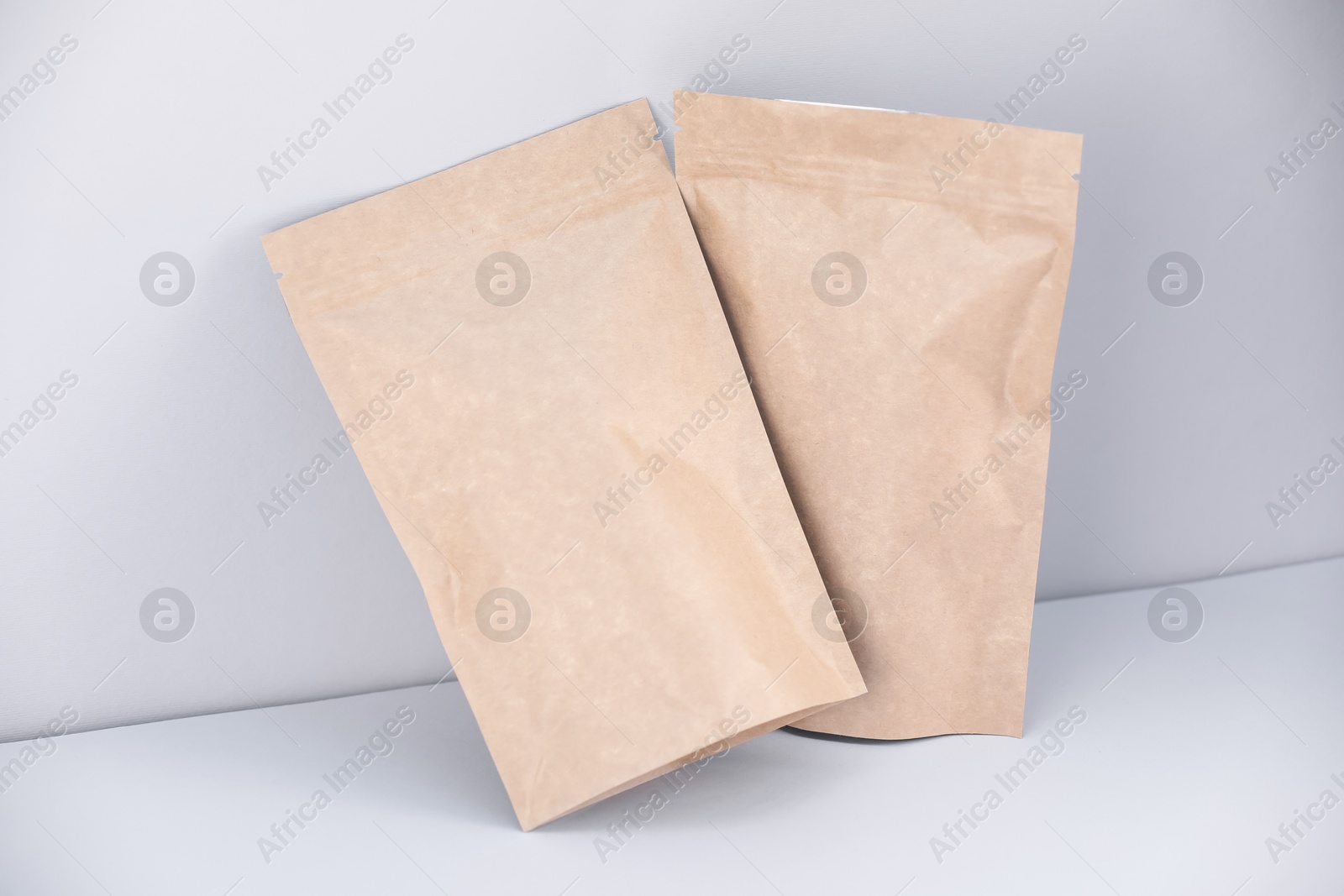 Zipper stand-up pouches on light grey background. Mockup for design Photo of Zipper stand-up pouches on light grey background. Mockup for design
