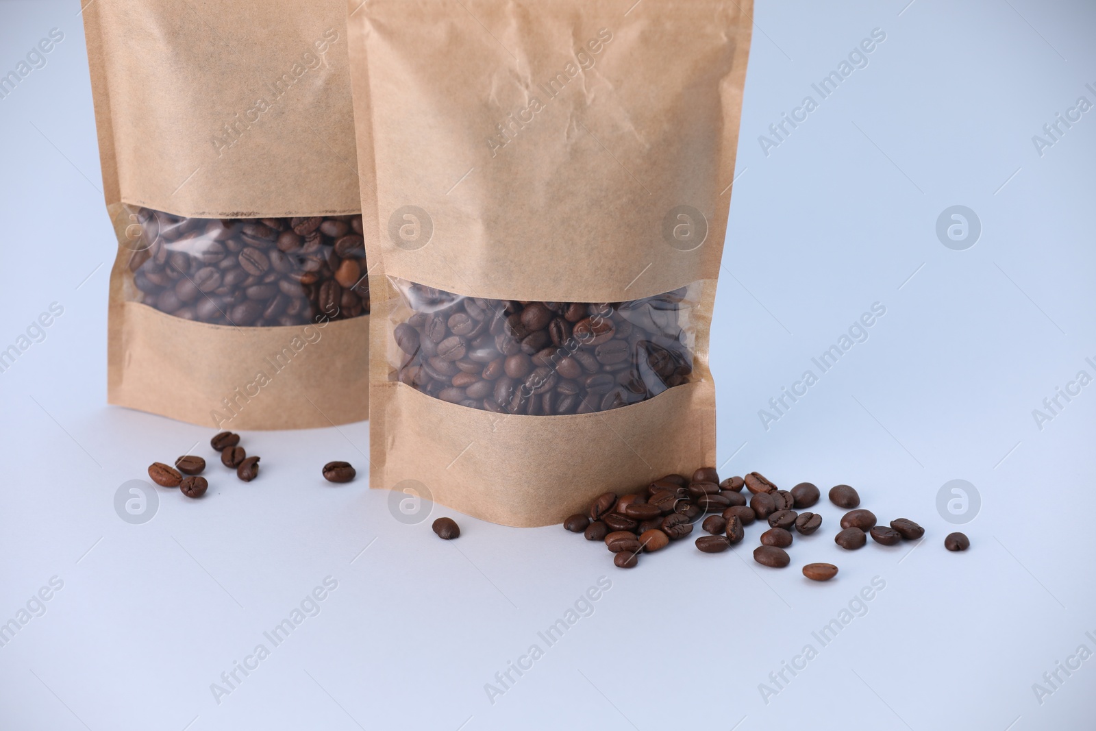 Zipper stand-up pouches with coffee beans on light grey background. Mockup for design Photo of Zipper stand-up pouches with coffee beans on light grey background. Mockup for design