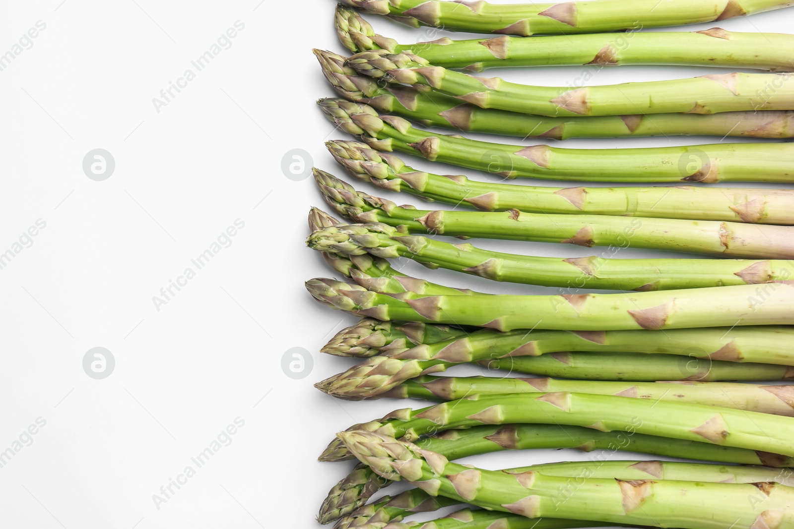 Fresh ripe raw asparagus on white background, flat lay Photo of Fresh ripe raw asparagus on white background, flat lay