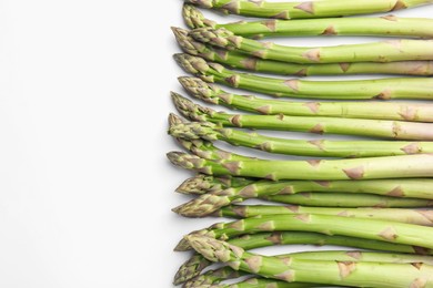 Photo of Fresh ripe raw asparagus on white background, flat lay