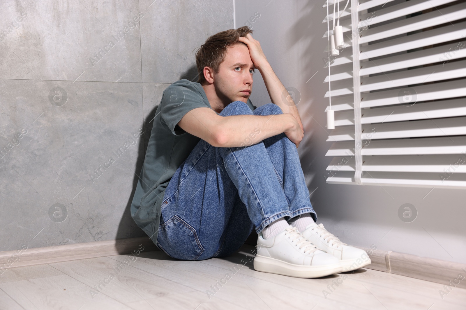 Man suffering from paranoia near window at home Photo of Man suffering from paranoia near window at home