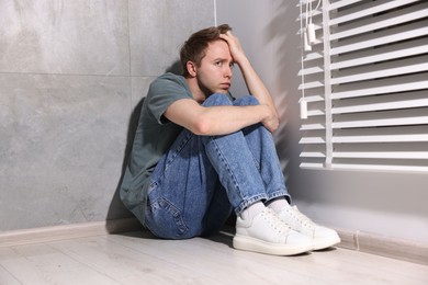 Photo of Man suffering from paranoia near window at home