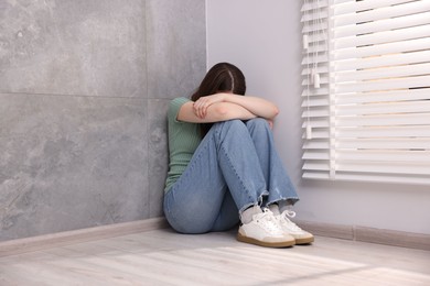 Photo of Woman suffering from paranoia near window at home