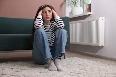 Photo of Woman suffering from paranoia on floor at home