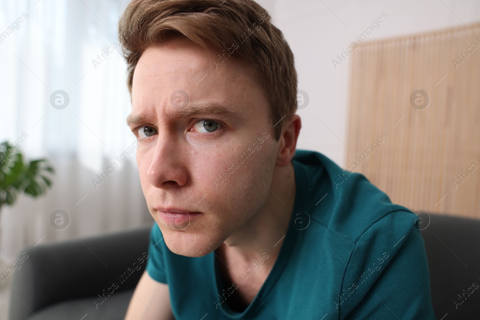 Scared man suffering from paranoia at home Photo of Scared man suffering from paranoia at home