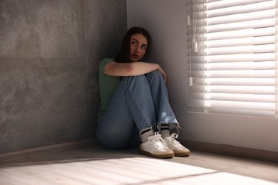 Photo of Woman suffering from paranoia near window at home