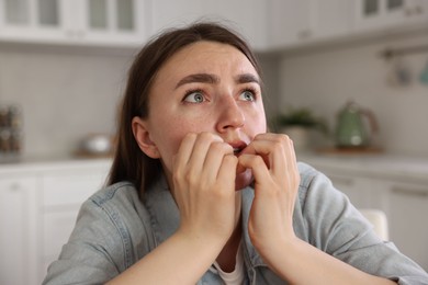 Photo of Worried woman suffering from paranoia in kitchen