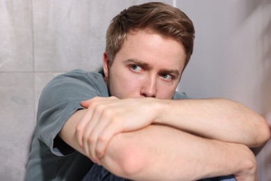 Photo of Scared man suffering from paranoia at home