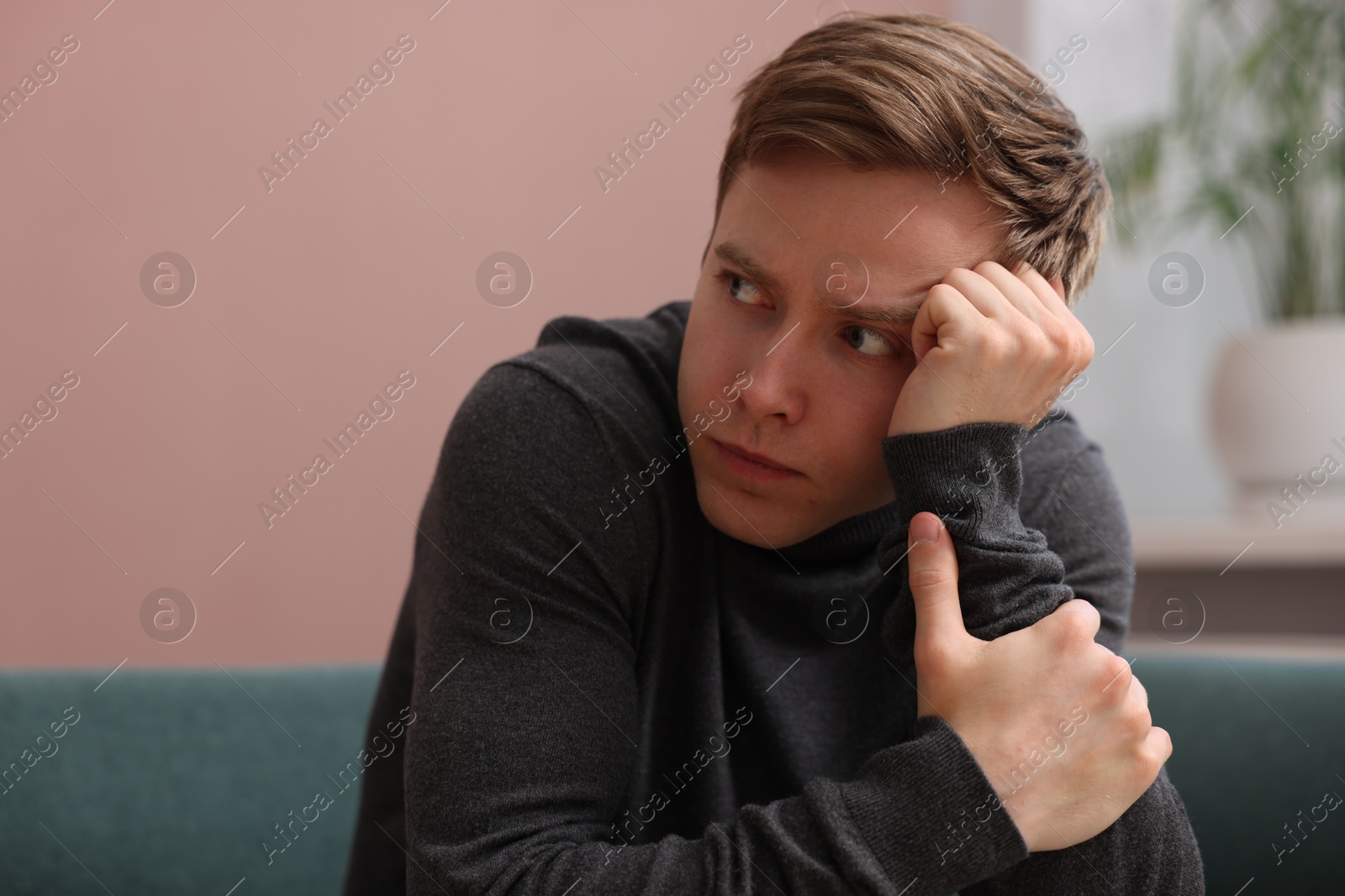 Scared man suffering from paranoia at home Photo of Scared man suffering from paranoia at home