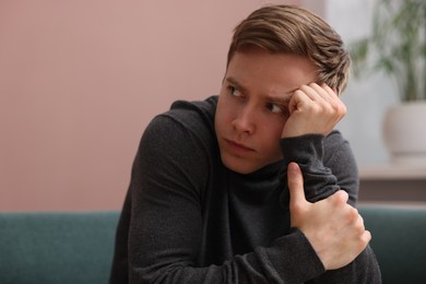 Photo of Scared man suffering from paranoia at home