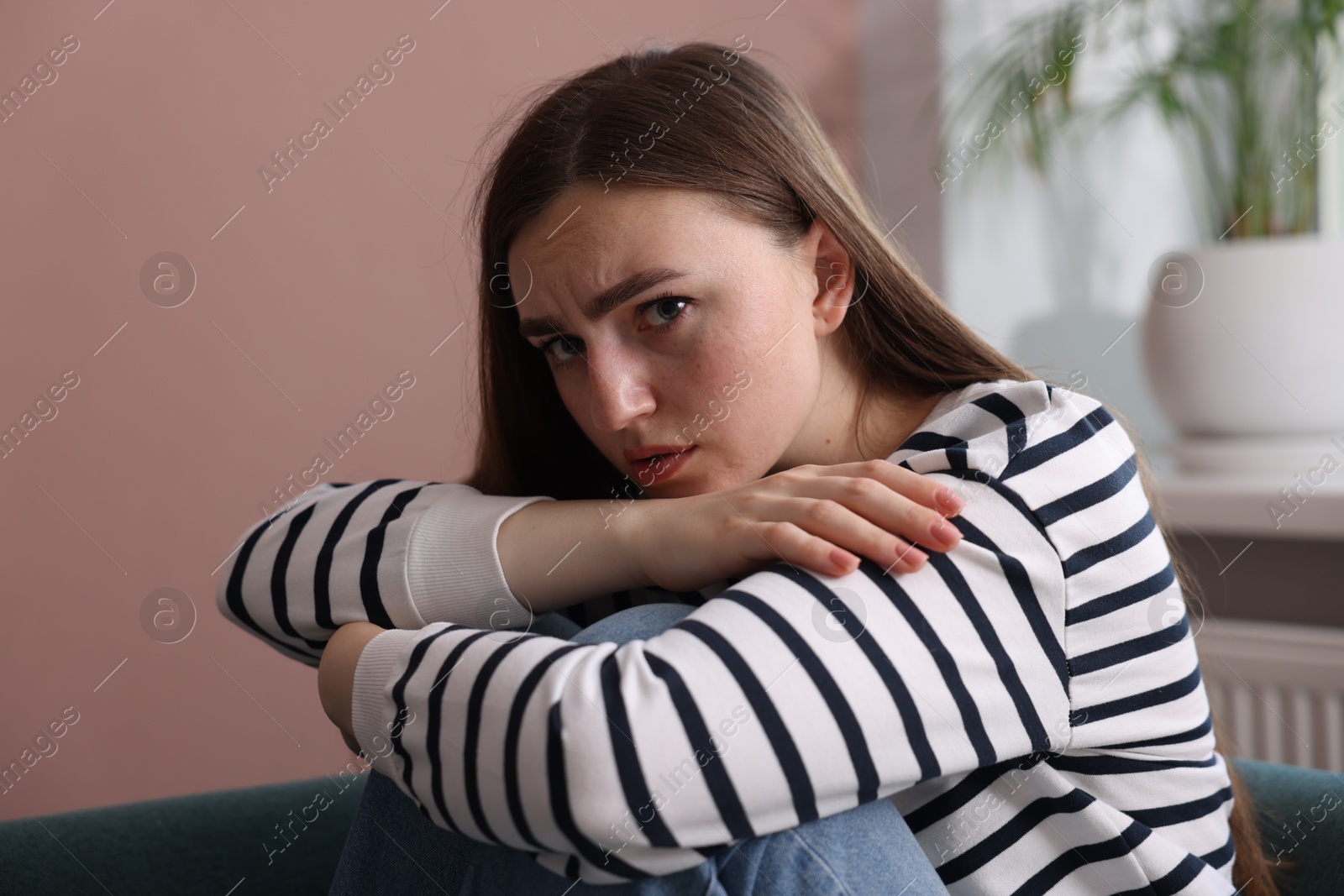 Worried woman suffering from paranoia at home Photo of Worried woman suffering from paranoia at home