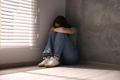 Photo of Woman suffering from paranoia near window at home