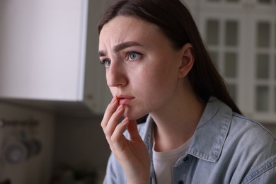 Photo of Worried woman suffering from paranoia in kitchen