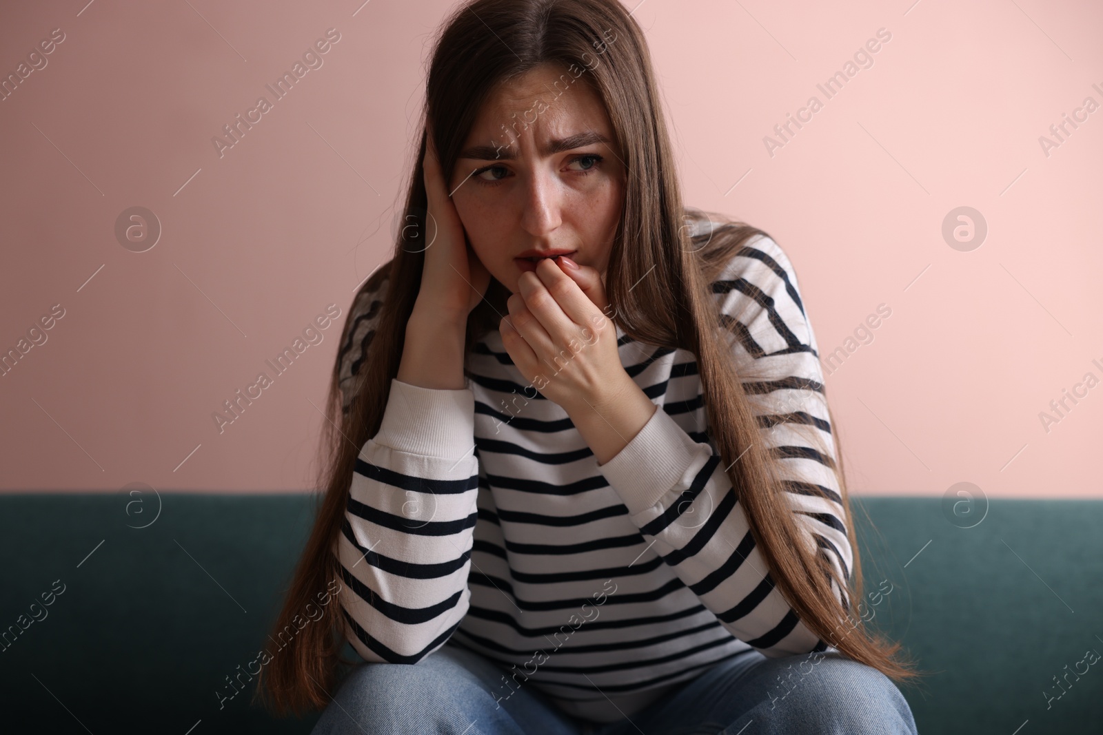 Worried woman suffering from paranoia on sofa indoors Photo of Worried woman suffering from paranoia on sofa indoors
