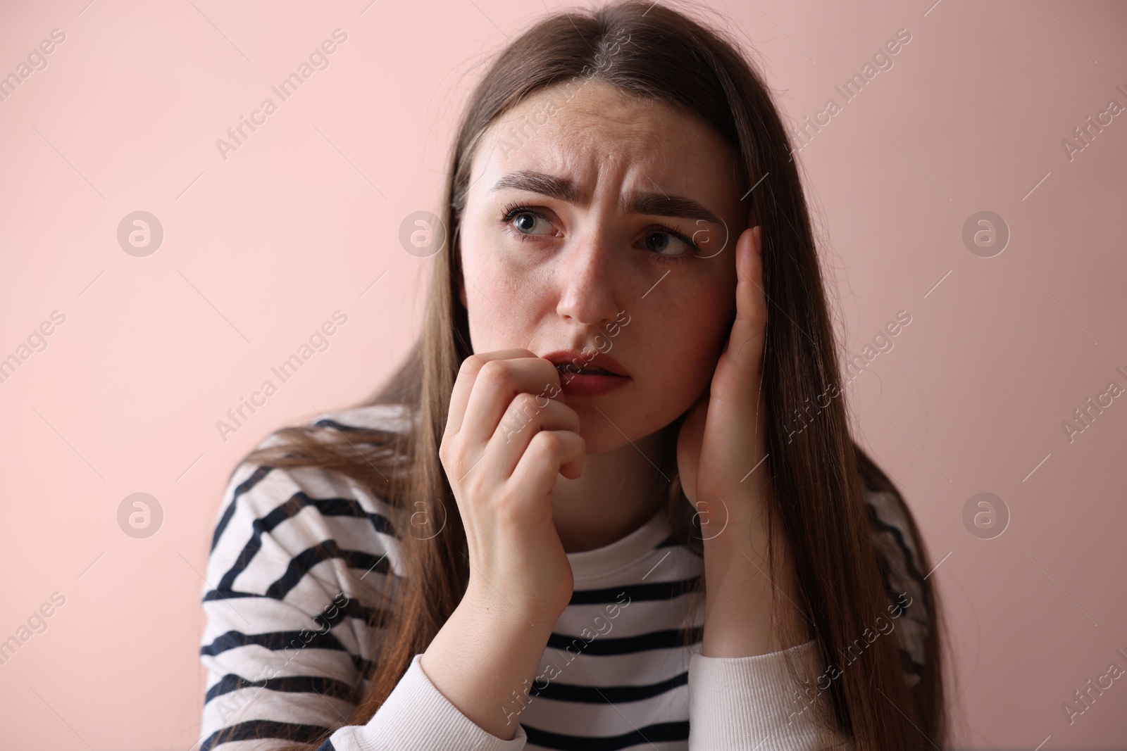 Worried woman suffering from paranoia near beige wall indoors Photo of Worried woman suffering from paranoia near beige wall indoors