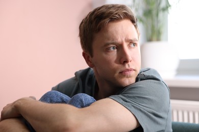 Photo of Scared man suffering from paranoia at home