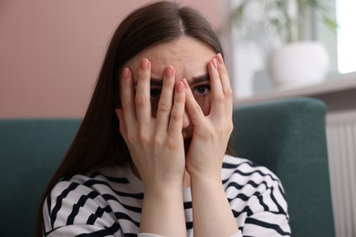 Photo of Scared woman suffering from paranoia at home