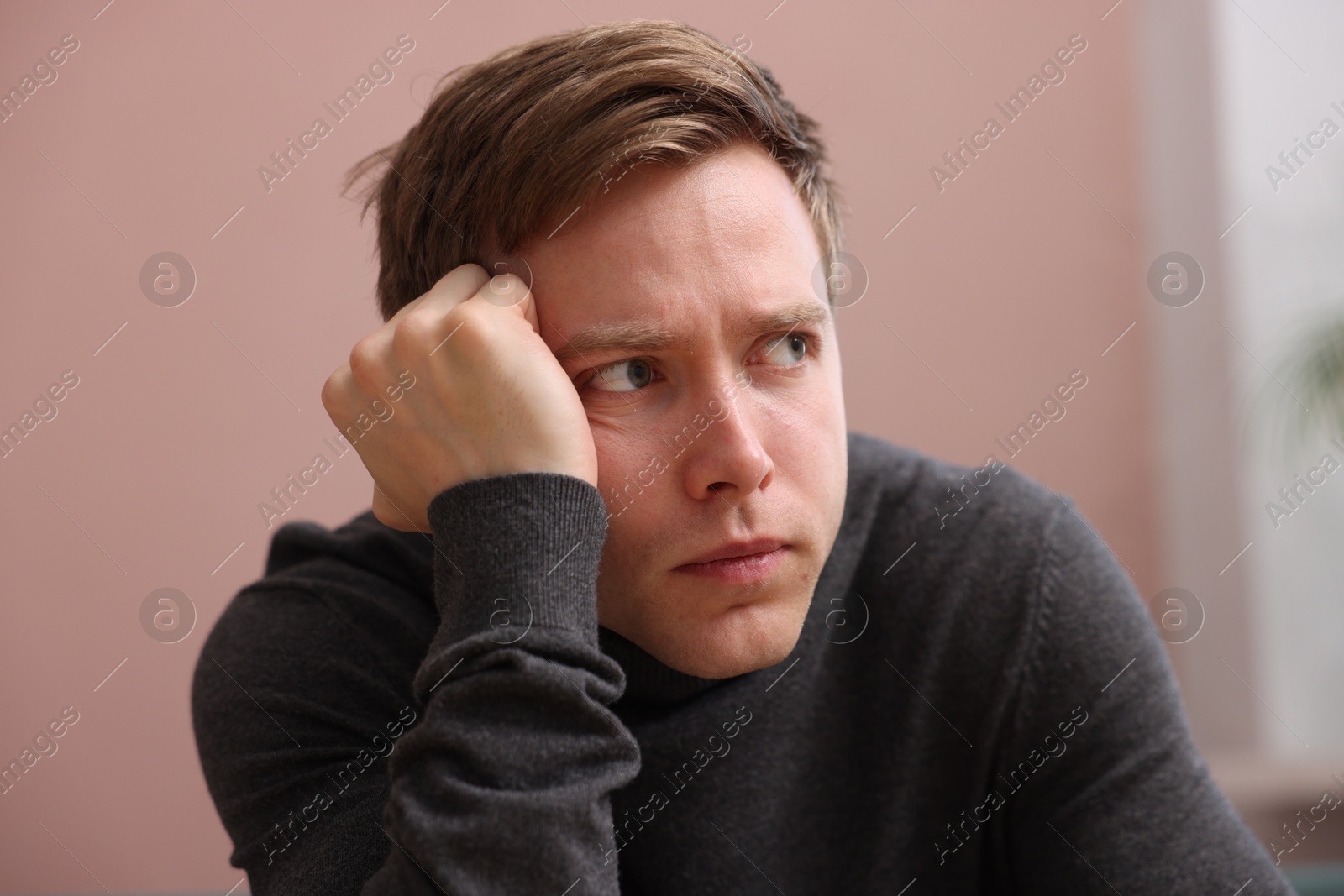 Scared man suffering from paranoia at home Photo of Scared man suffering from paranoia at home