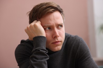 Photo of Scared man suffering from paranoia at home