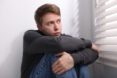 Photo of Man suffering from paranoia near window at home