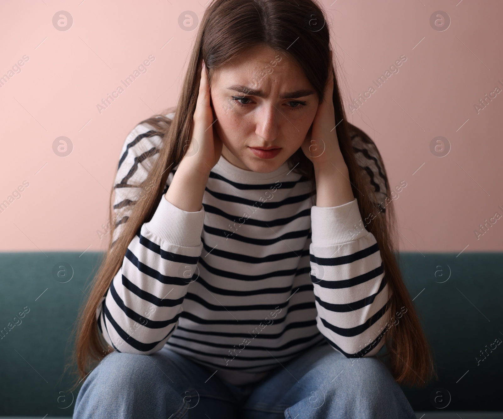Woman suffering from paranoia on sofa at home Photo of Woman suffering from paranoia on sofa at home