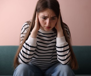 Photo of Woman suffering from paranoia on sofa at home