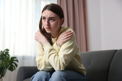 Photo of Woman suffering from paranoia on sofa at home
