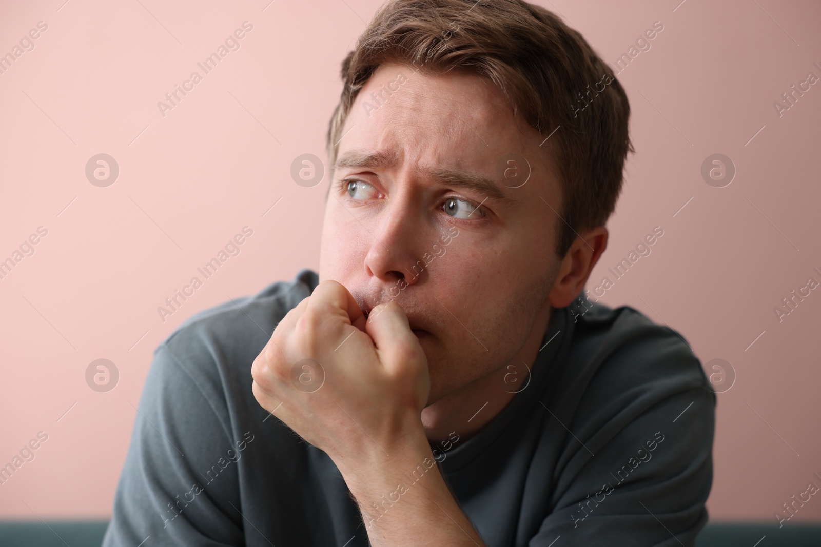 Scared man suffering from paranoia near beige wall indoors Photo of Scared man suffering from paranoia near beige wall indoors