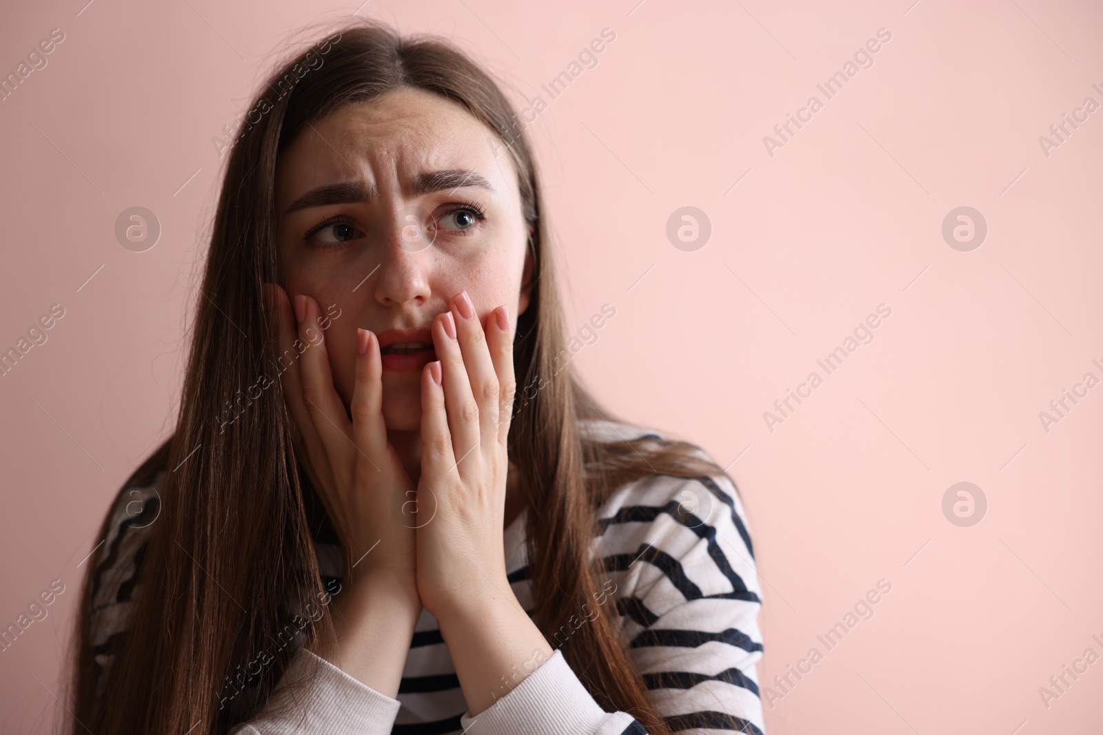Scared woman suffering from paranoia near beige wall indoors, space for text Photo of Scared woman suffering from paranoia near beige wall indoors, space for text