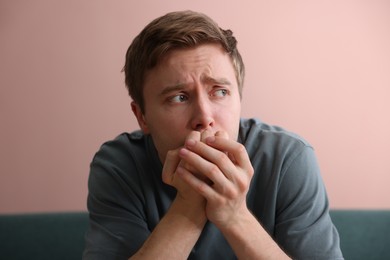 Photo of Scared man suffering from paranoia at home