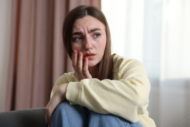 Photo of Scared woman suffering from paranoia at home