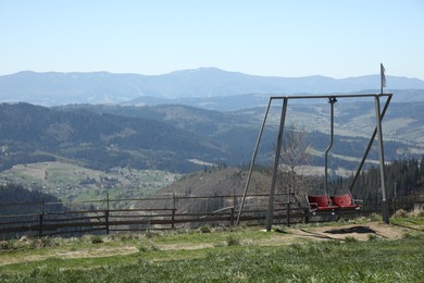 Photo of Picturesque view of wooden fence and swing near mountains, space for text