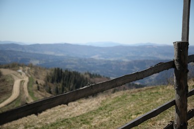 Photo of Picturesque view of wooden fence near mountains and forest
