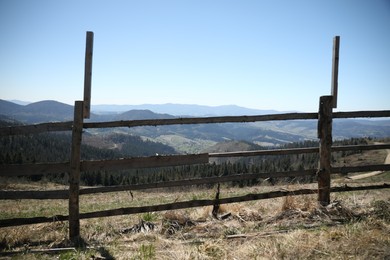 Photo of Picturesque view of wooden fence near mountains and forest