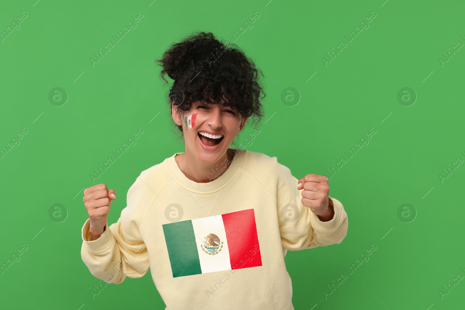 Excited fan with flag of Mexico on her sweater against green background Image of Excited fan with flag of Mexico on her sweater against green background