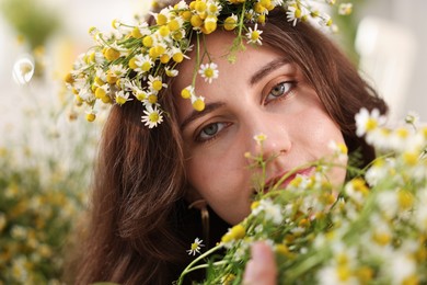 Photo of Portrait of beautiful woman with chamomile flowers indoors