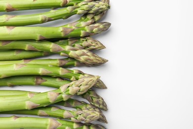 Photo of Fresh ripe raw asparagus on white background, flat lay