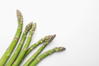 Photo of Fresh ripe raw asparagus on white background, flat lay. Space for text