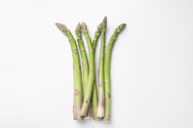 Photo of Fresh ripe raw asparagus on white background, flat lay