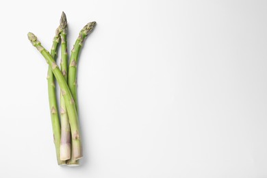 Photo of Fresh ripe raw asparagus on white background, top view. Space for text