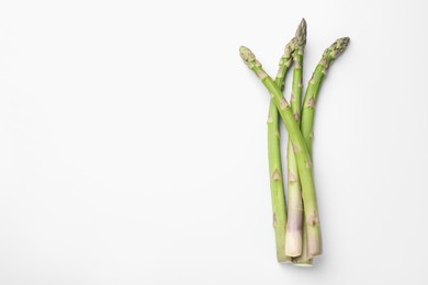 Photo of Fresh ripe raw asparagus on white background, top view. Space for text
