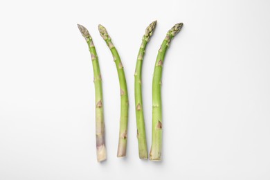 Photo of Fresh ripe raw asparagus on white background, flat lay